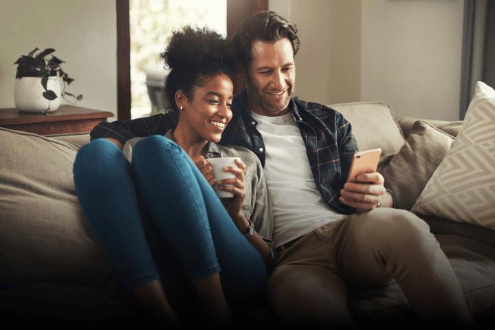 Happy couple sitting on the lounge in their home