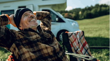 A man relaxing in front of him motorhome that he lives in full time.