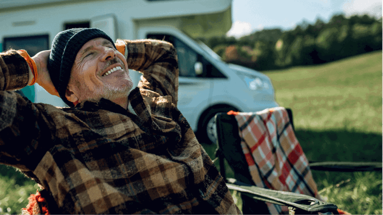 A man relaxing in front of him motorhome that he lives in full time.