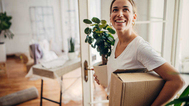 A woman carrying a box moving out of home