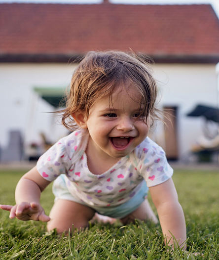 Baby crawling in front of house.